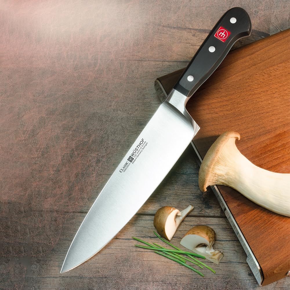 Wüsthof Classic 8-inch forged chef's knife with black triple-riveted handle resting on a wooden cutting board