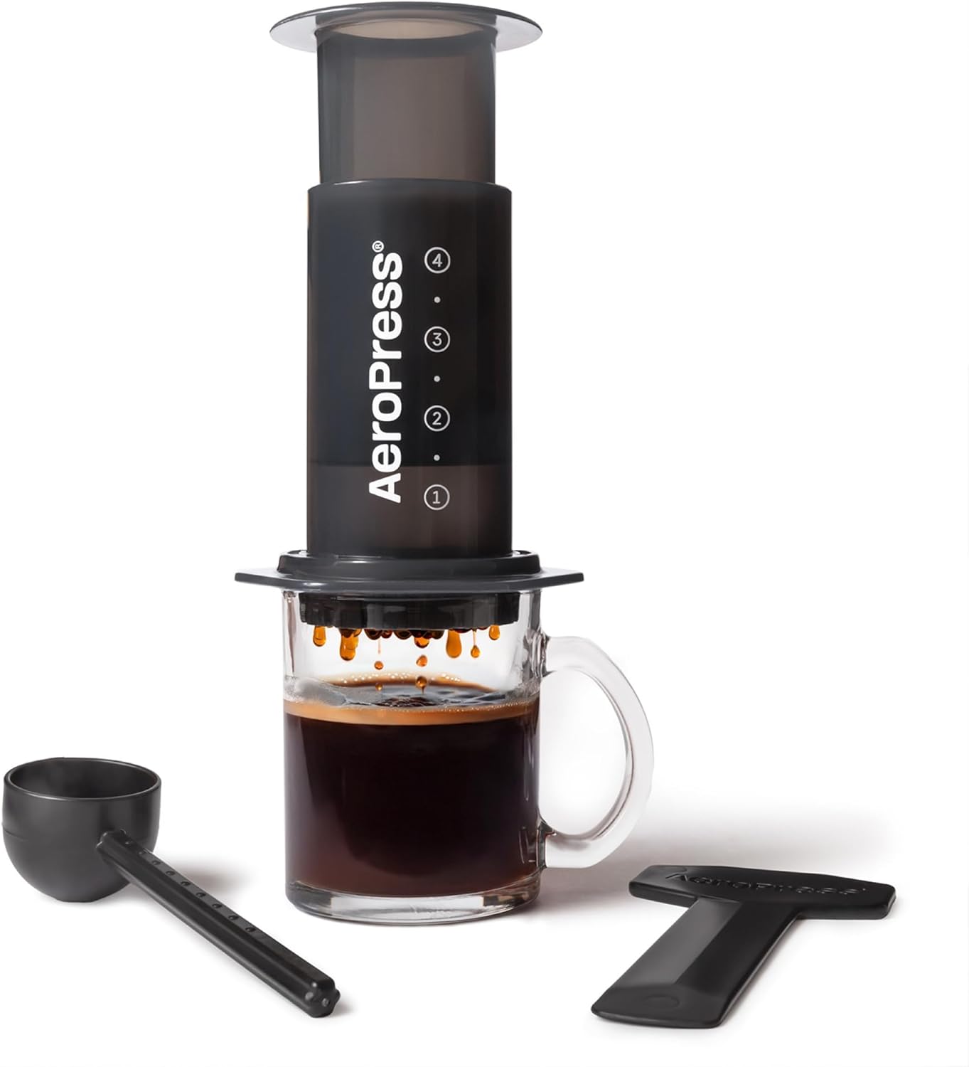 AeroPress Original coffee press, black plastic cylinder with grey plunger and spare paper filters on a kitchen counter