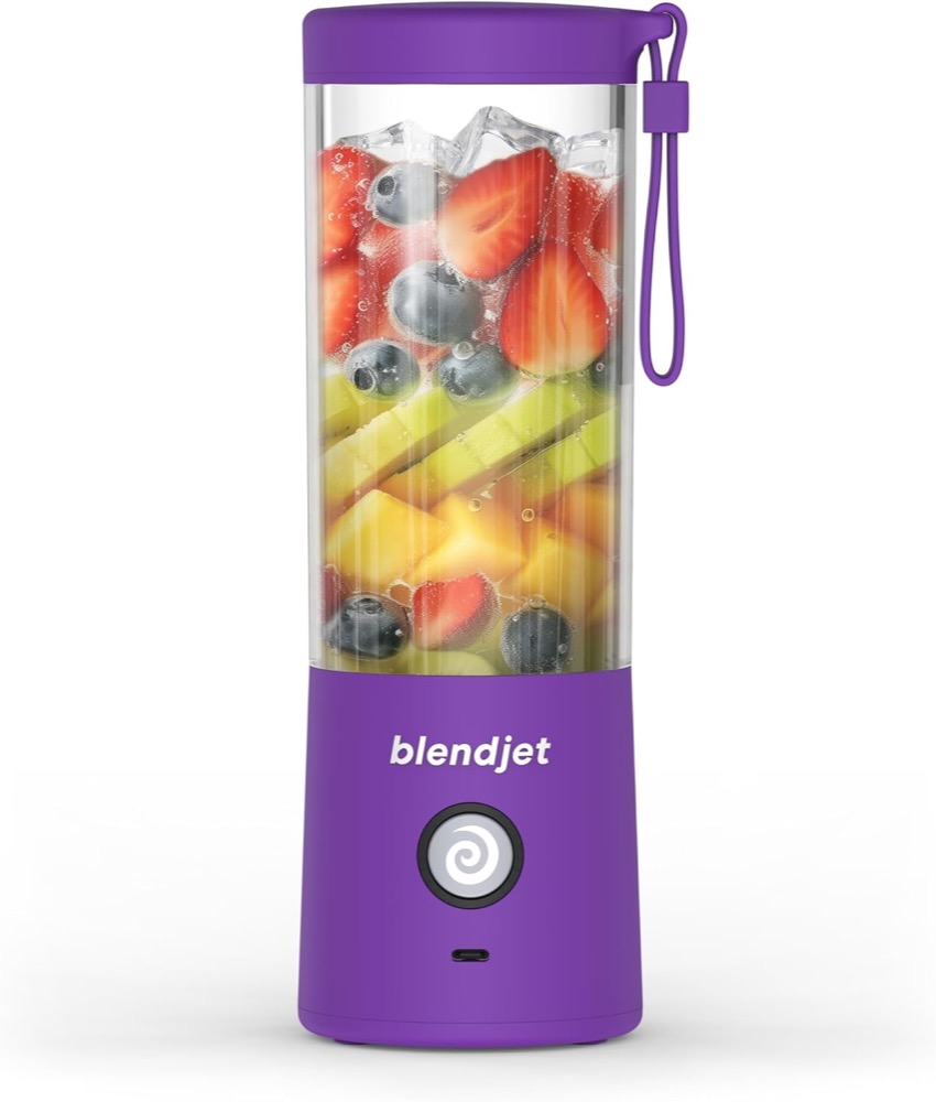 BlendJet 2 purple 16 oz portable blender filled with strawberries, blueberries and kiwi, with a purple carrying loop