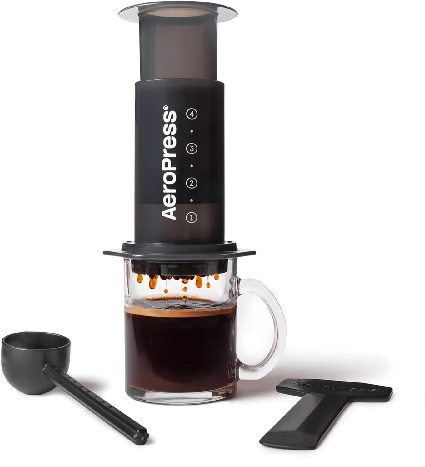 AeroPress Original coffee press, black plastic cylinder with grey plunger and spare paper filters on a kitchen counter